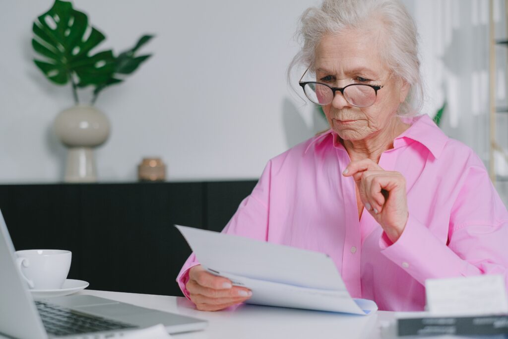 Seniorin mit Dokumenten und Brille