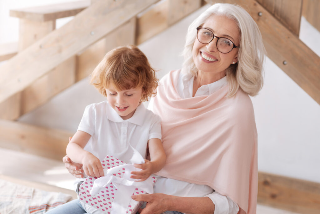 Oma mit Enkel packt Geschenk aus