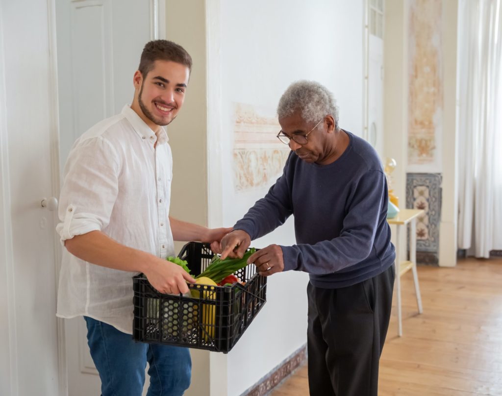 Mann hilft Senior beim Einkaufen