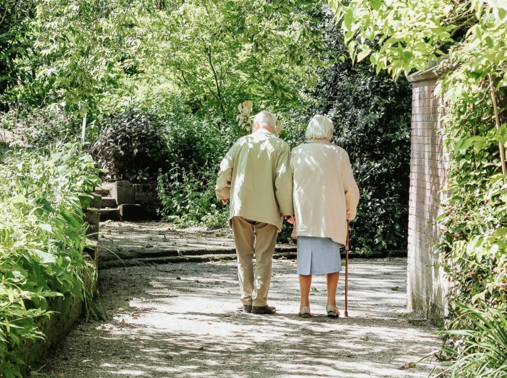 Senioren Paar spaziert durch Wald