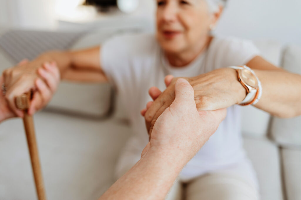 Seniorin mit Gehstock auf dem Sofa