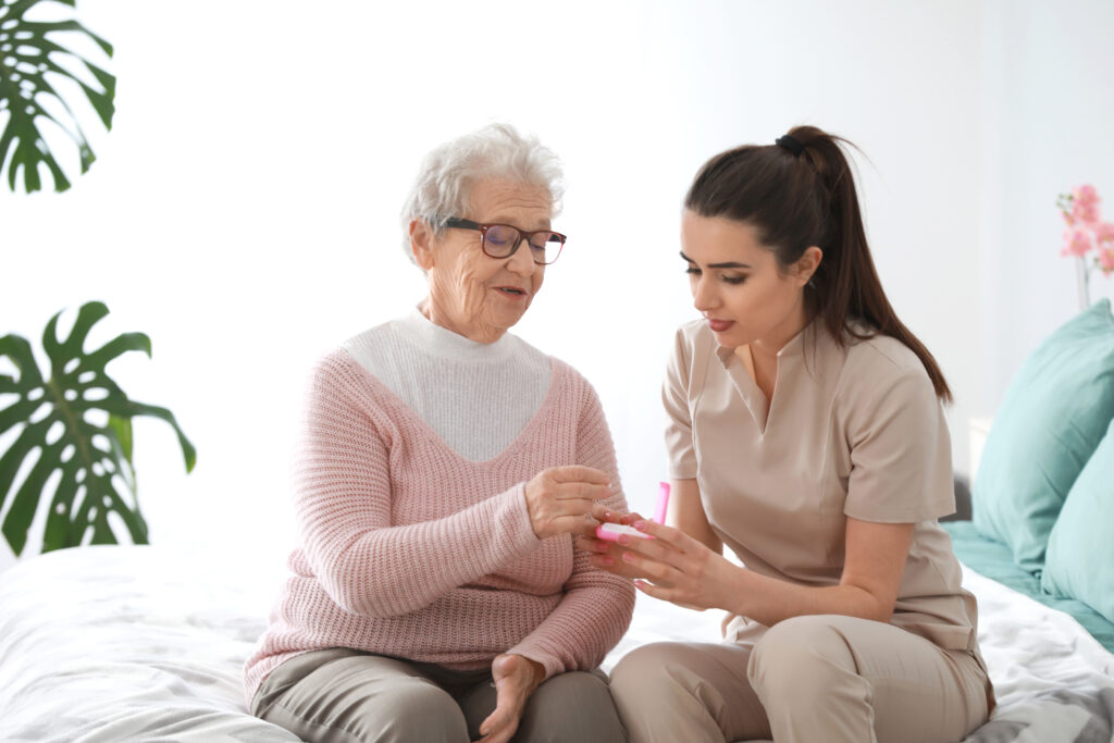 Pflegerin gibt einer Seniorin Medizin