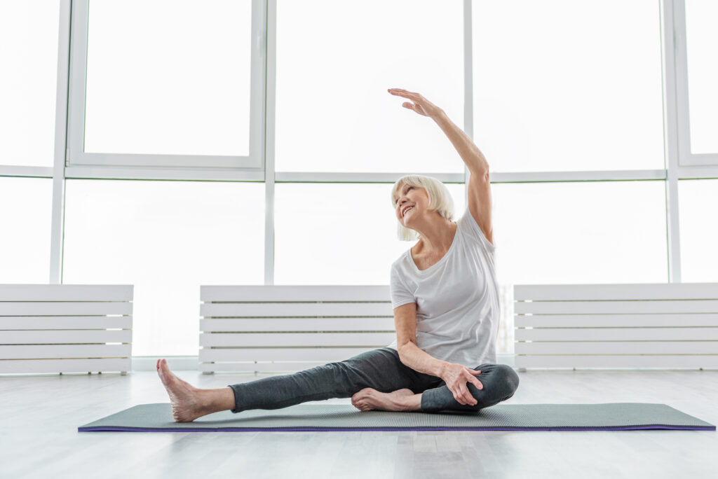 Seniorin beim Yoga dehnt sich