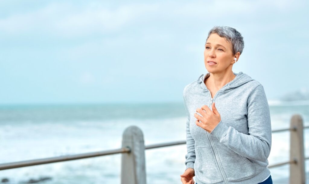 Ältere Frau joggt am Meer